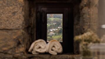 Eine Steinsäule mit einem kleinen Fenster, das einen Blick auf ein Dorf bietet.