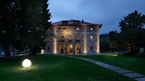 Un edificio de piedra con varios arcos y una entrada bien iluminada.