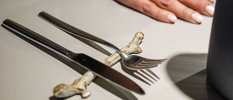 A dining table with a wine glass, a fork, and a knife.