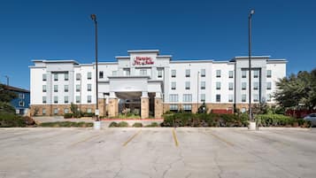 Um hotel Hampton Inn & Suites com um estacionamento em frente.