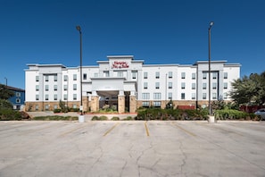 A Hampton Inn & Suites hotel with a parking lot in front.