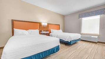 Une chambre d’hôtel avec deux lits, une table de chevet, un téléphone et une fenêtre donnant sur un paysage agréable.
