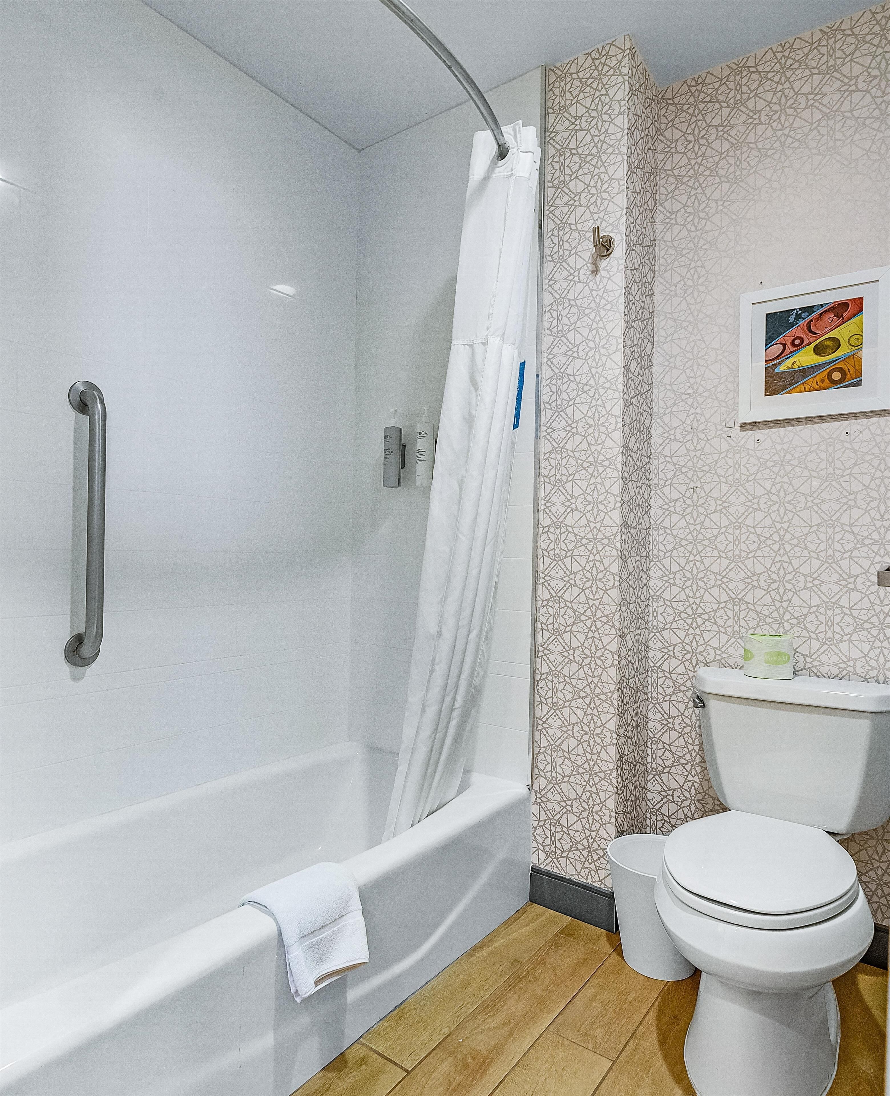 A bathroom with a shower, toilet, and sink.
