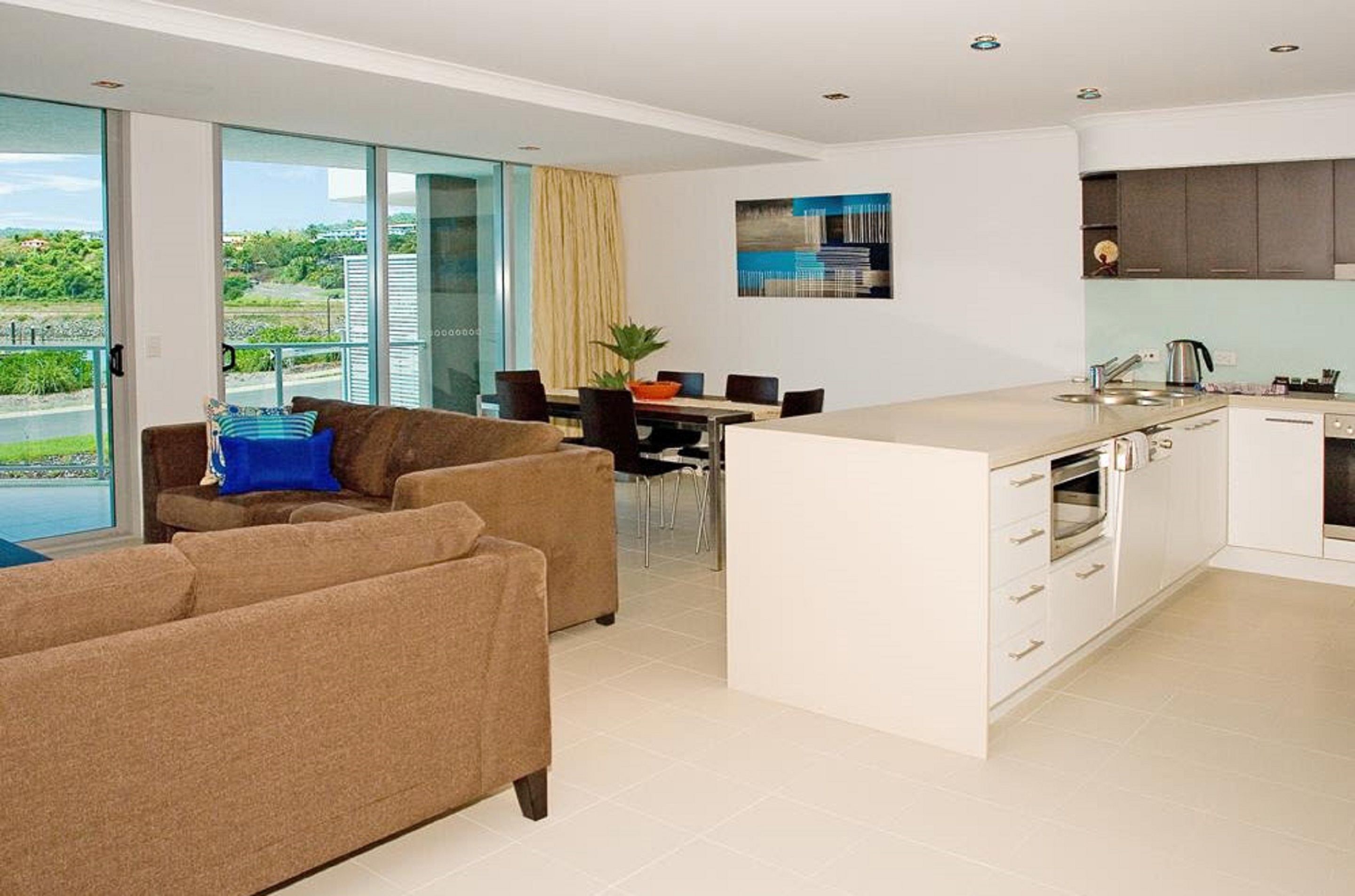 A modern kitchen with white cabinets and a dining area with a table and chairs.