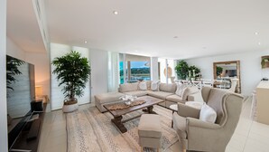 Amplia sala de estar con un sofá seccional grande, una mesa de centro y vistas al exterior.