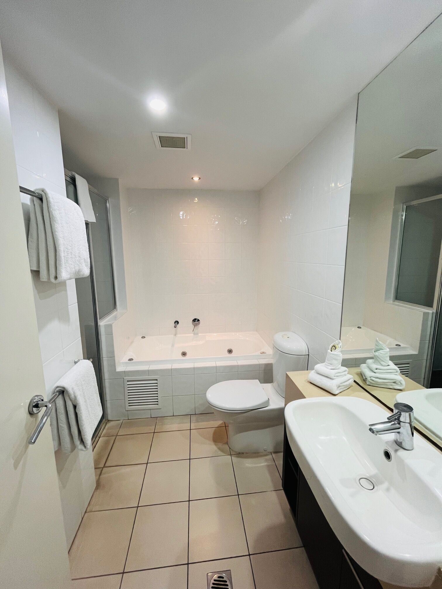 A modern bathroom with a bathtub, toilet, and sink.