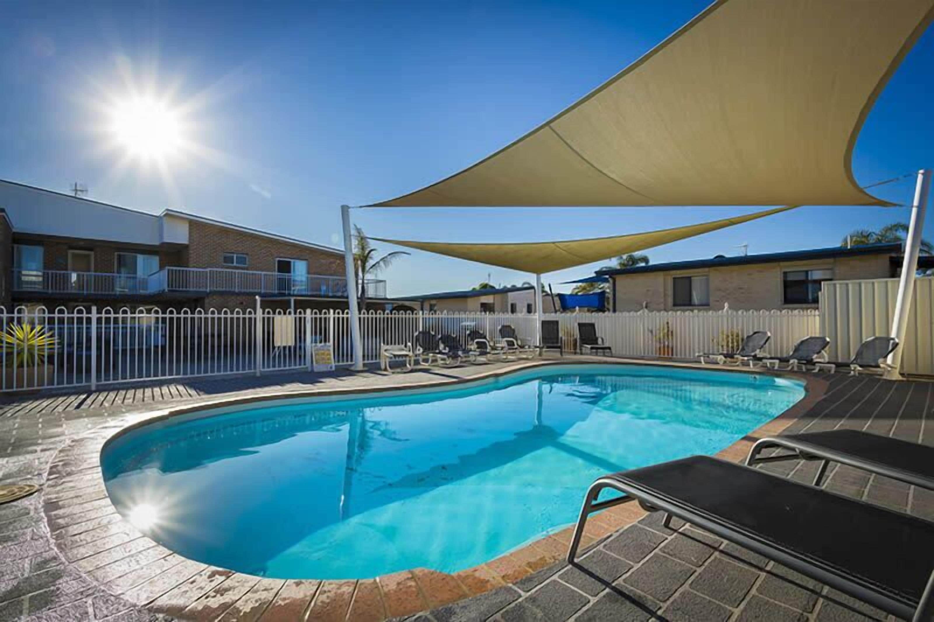 حمّام سباحة خارجي، مظلات على حمّام السباحة، مقاعد للتشمس