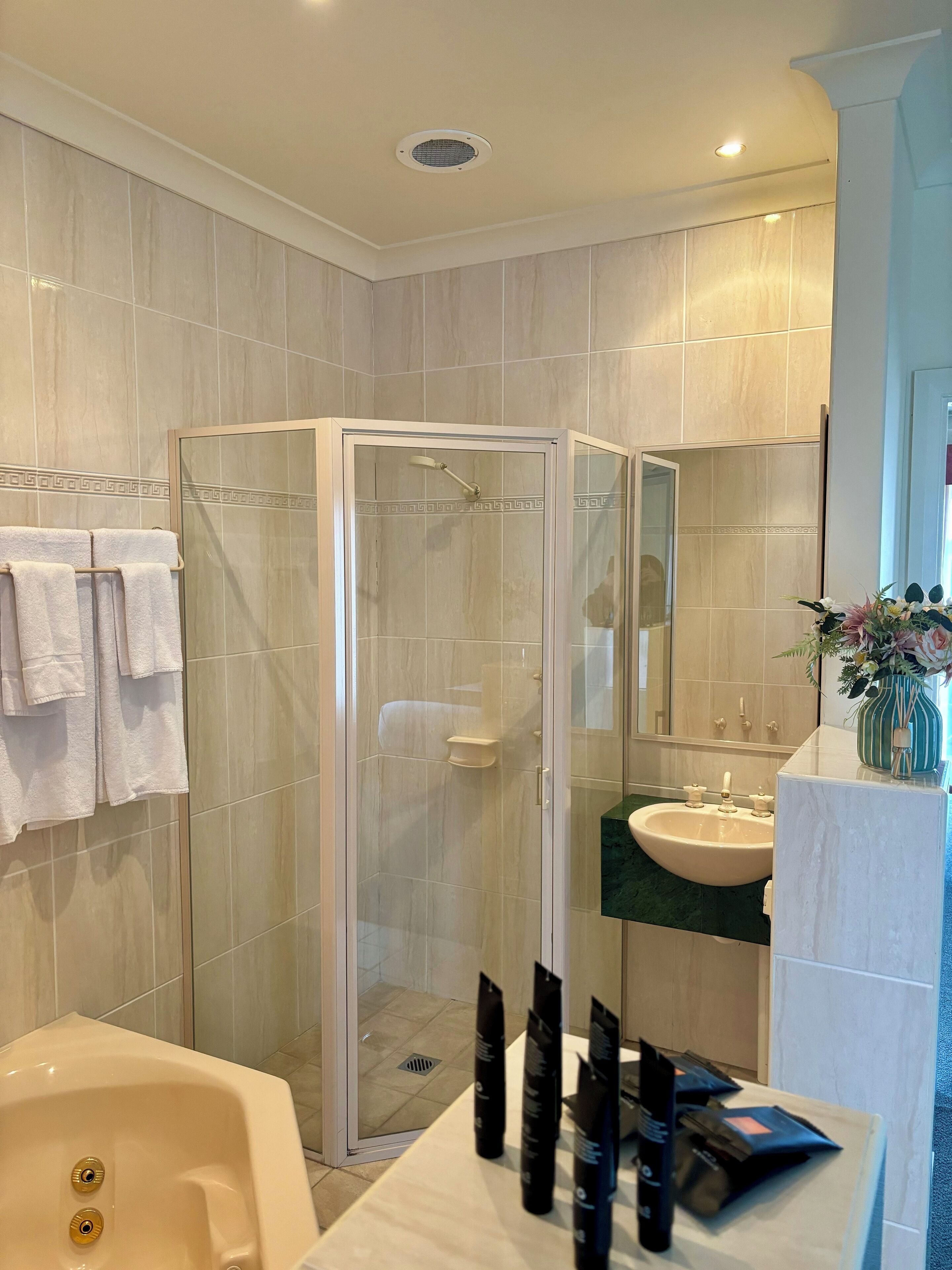A modern bathroom with a glass-enclosed shower, a bathtub, and a vanity with a sink.