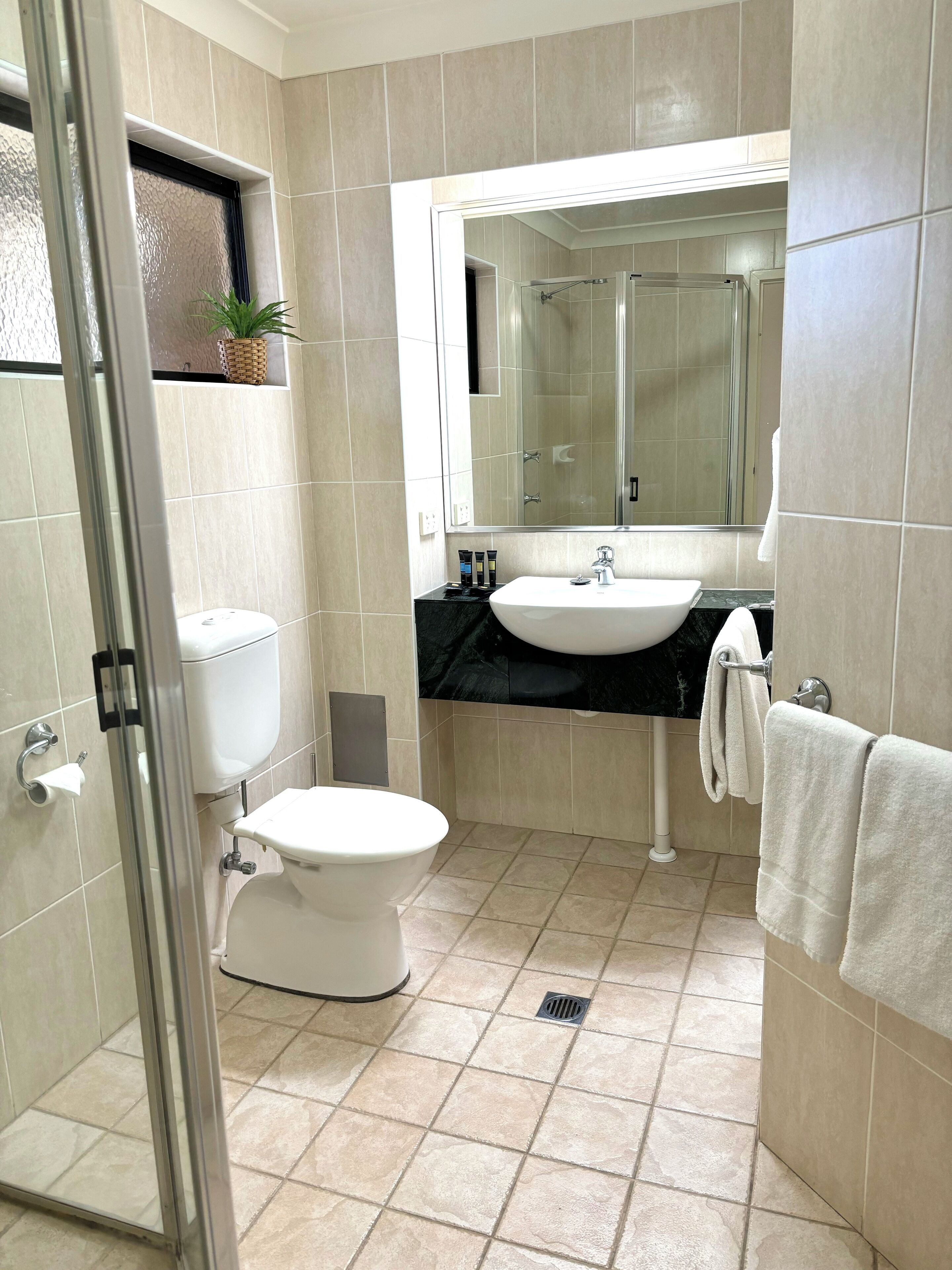 A modern bathroom with a toilet, bidet, and sink.