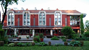 A red and white building with multiple entrances, including a restaurant, hotel, and fitness center.