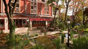 A restaurant with outdoor seating and a garden area.