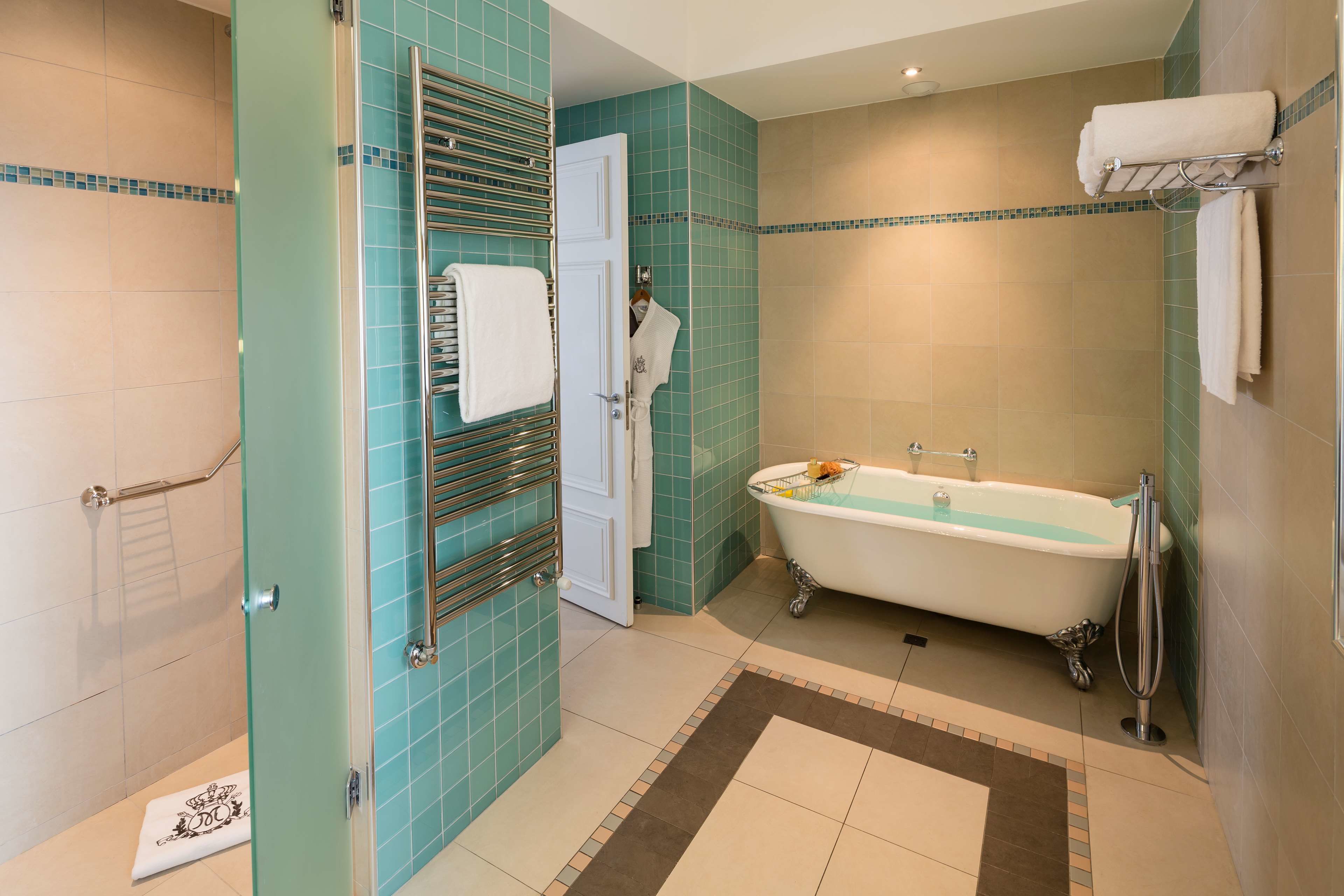Une salle de bain équipée d’une baignoire, d’un porte-serviettes et d’un espace douche.