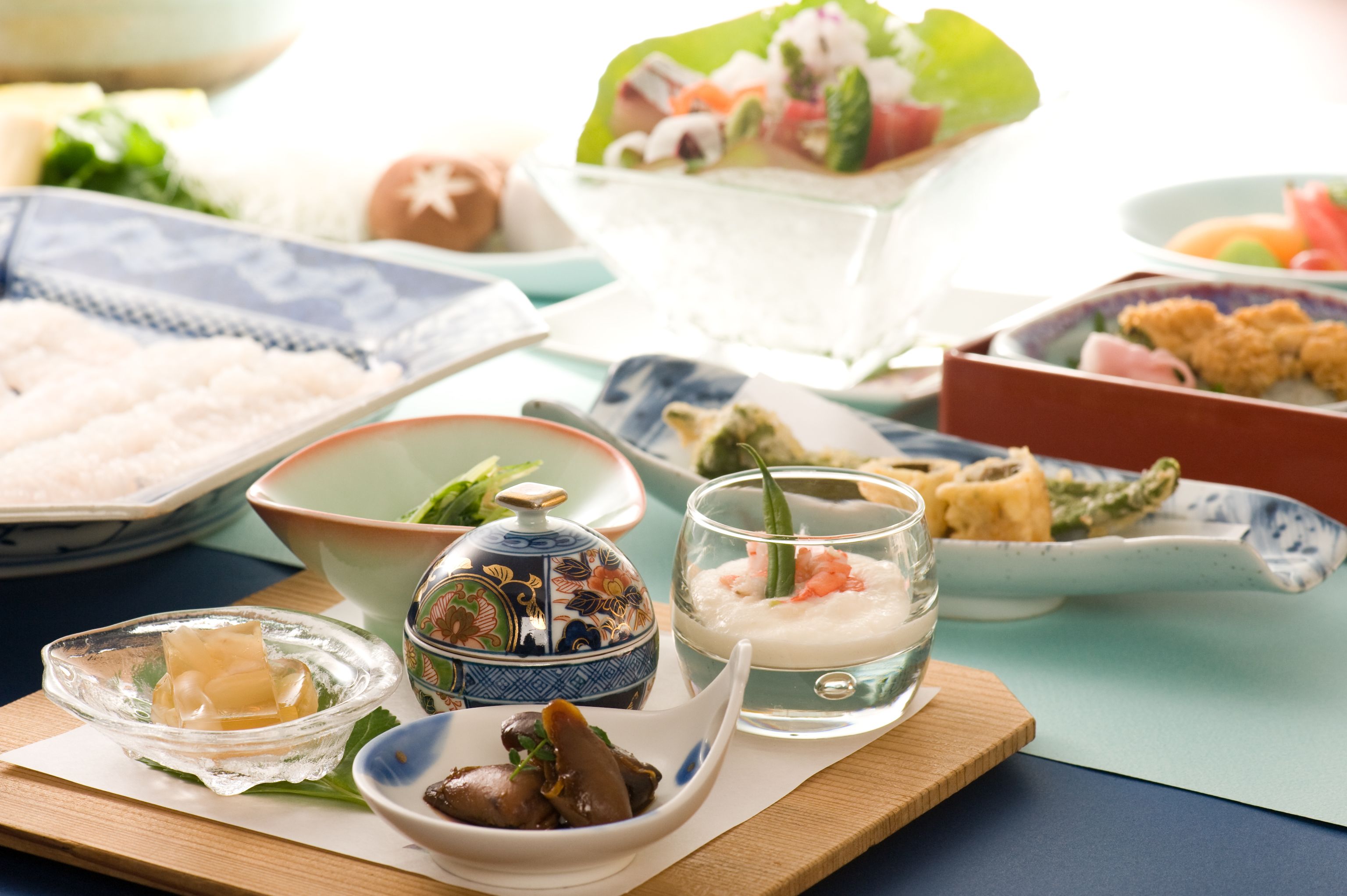 A variety of dishes on a table, including sushi, sashimi, and other Japanese cuisine.