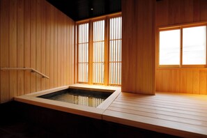 Un onsen japonais traditionnel, avec des murs en bois et une terrasse en bois.
