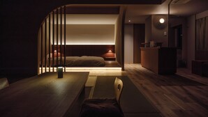 A modern, dimly lit room with a bed, a desk, and a chair. - Negiya Ryofukaku (Kobe)