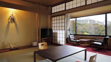 A traditional Japanese room with tatami flooring, a low table, and seating.