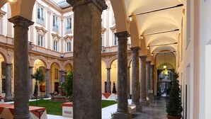 Ein geräumiger Korridor mit hohen Decken und klassizistischer Architektur, mit Säulen und Bögen.