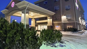 Un hotel de varios pisos con entrada cubierta, zona de estar al aire libre y aparcamiento.