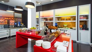 Montaje de buffet con una barra roja, diversas opciones de comida y un fondo de estantes etiquetados 'season' y 'blend'.