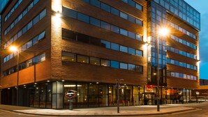 Un edificio moderno de varios pisos con fachada de vidrio y detalles de ladrillo.