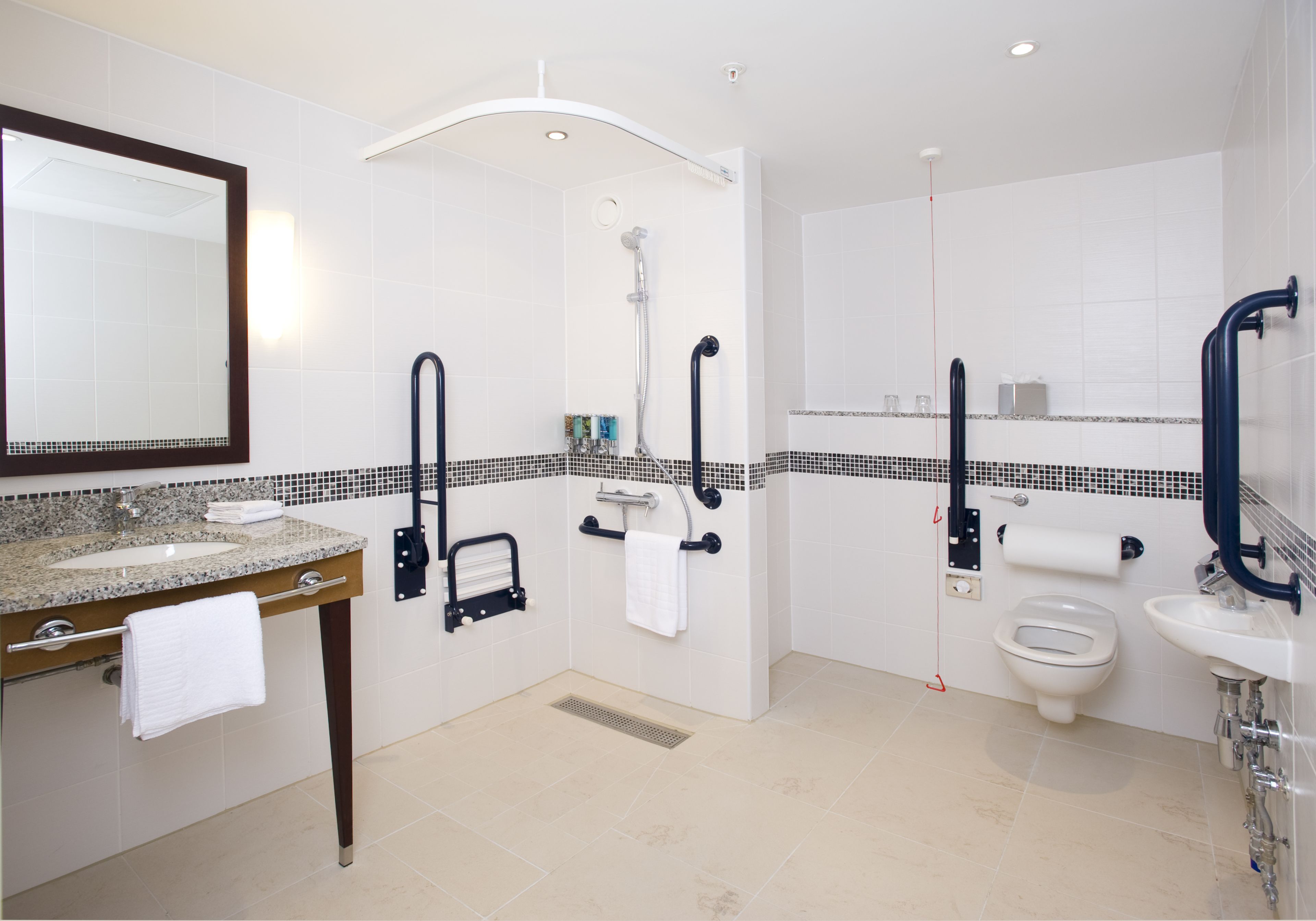 Ein modernes Badezimmer mit einem Granitwaschbecken, einer Toilette, einem Bidet und einer Dusche.