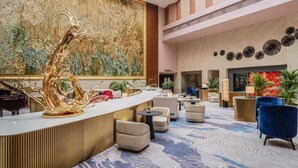 A spacious lobby with a grand piano, a large abstract painting, and a modern reception desk. - Marco Polo Jinjiang (Quanzhou)