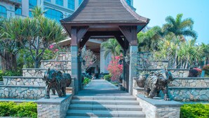A covered walkway with steps leading to a building, flanked by stone walls and statues of elephants. - Marco Polo Jinjiang (Quanzhou)