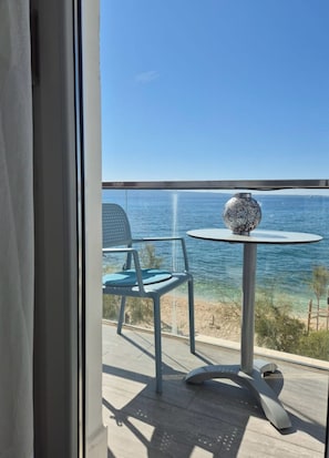 A balcony with a table and chairs, overlooking a beach and the sea. - Villa Zanic (Podstrana)