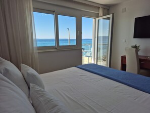 A hotel room with a bed, a desk, and a view of the sea. - Villa Zanic (Podstrana)