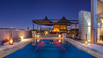 Una piscina al aire libre, sombrillas