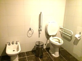 Un baño con lavabo, inodoro, bidé y cubo de basura.