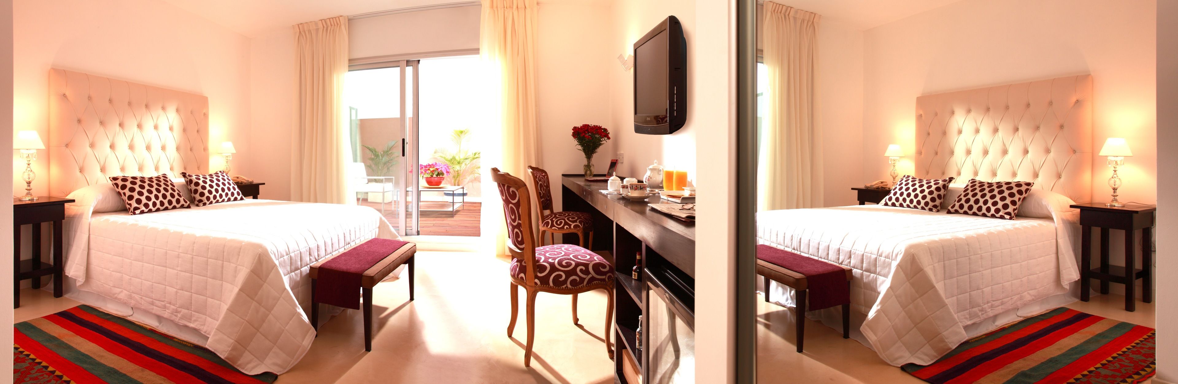 Une chambre d’hôtel avec deux lits, un bureau, une chaise et une vue sur l’extérieur.