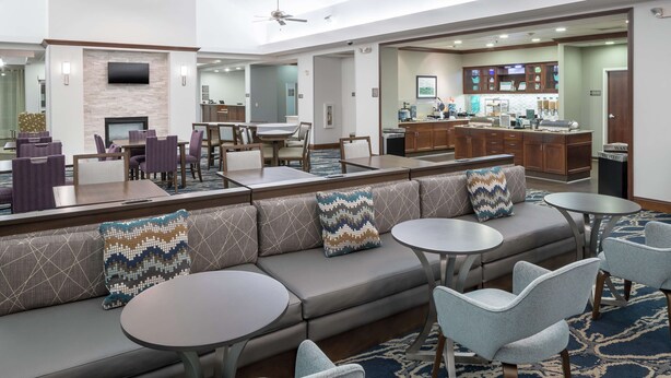 A modern hotel lobby with a seating area, a bar, and a dining area. - Homewood Suites by Hilton  Fresno Airport/Clovis, CA (Clovis)