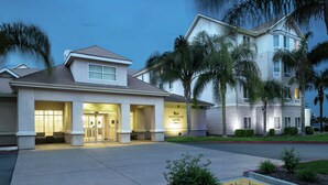 A hotel with a modern design, featuring a well-lit entrance and a sign that reads "Homewood Suites." - Homewood Suites by Hilton  Fresno Airport/Clovis, CA (Clovis)