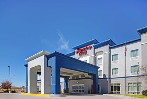 A Hampton Inn hotel with a clear sky and a blue and white facade.