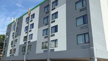 A multi-story building with a flat facade, large windows, and a green roof.