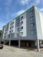 Un edificio de varios pisos con fachada plana, ventanas grandes y techo verde.