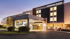 A modern hotel with a covered entrance, large windows, and a sign reading "Springhill Suites by Marriott."