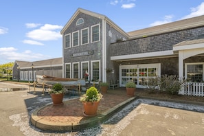 Classic hotel with a gabled roof and welcoming entrance, surrounded by lush landscaping and a nautical touch.