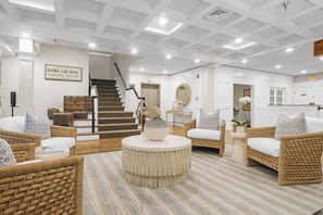 Step into a stylish lobby with a staircase, reception desk, and comfortable seating areas.