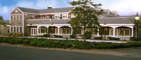 A two-story building with a large porch and multiple windows.