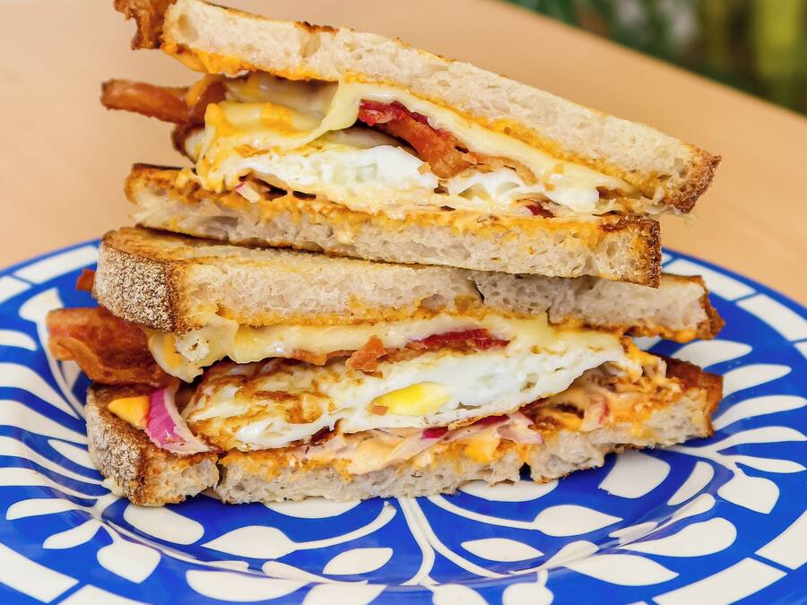 En stabel sandwiches på en blå og hvid tallerken.