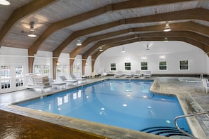 Relax by the pool surrounded by lounge chairs and sunbeds.