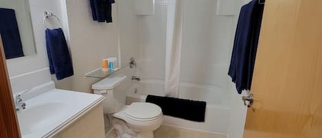 Uma casa de banho com sanita, lavatório e banheira.
