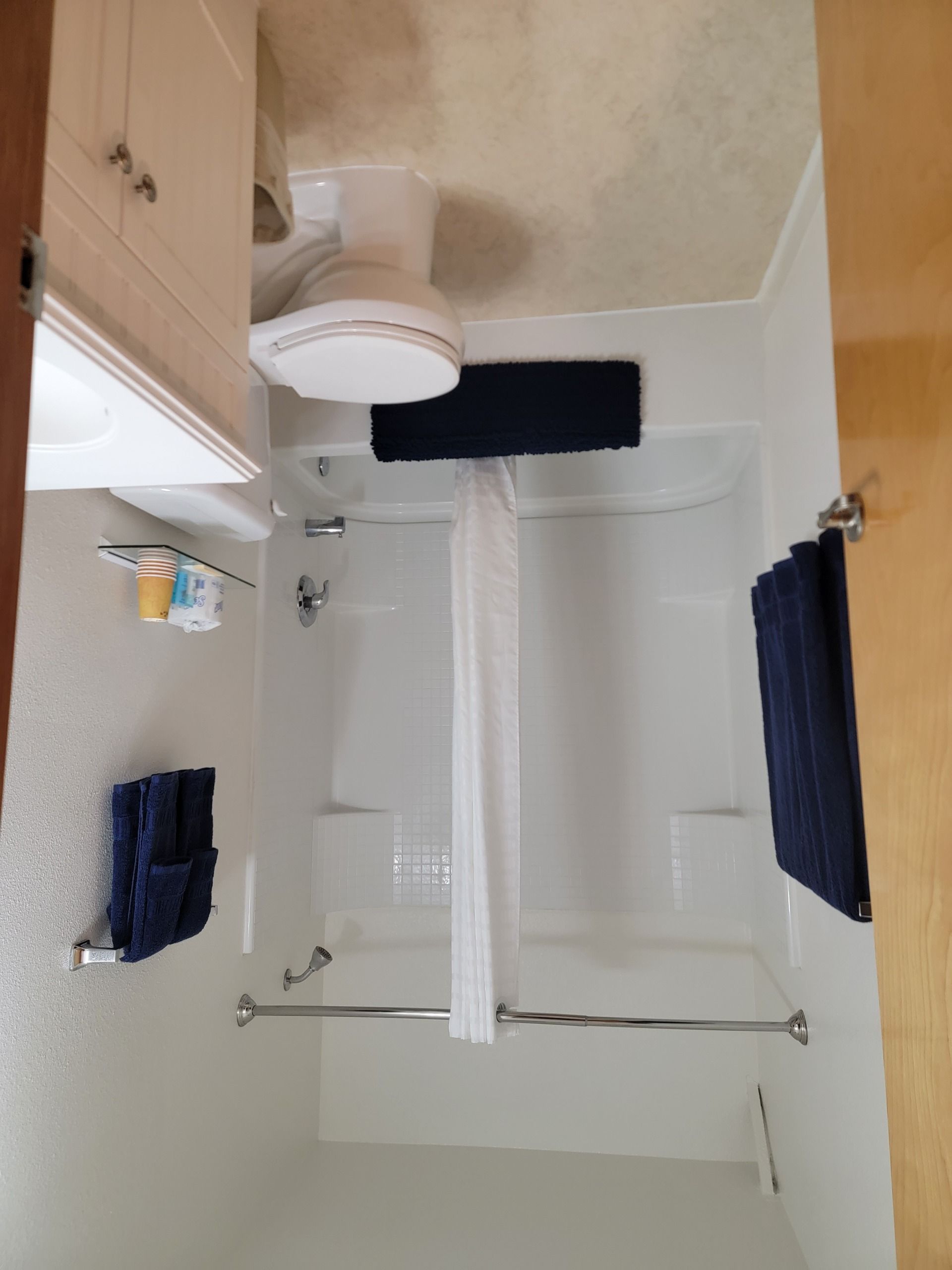 A bathroom with a bathtub, a toilet, a shower, and a towel rack.