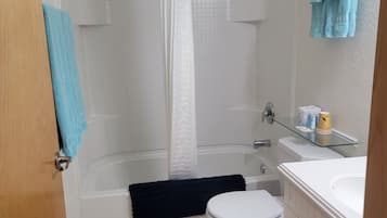 A bathroom with a bathtub, toilet, and sink.