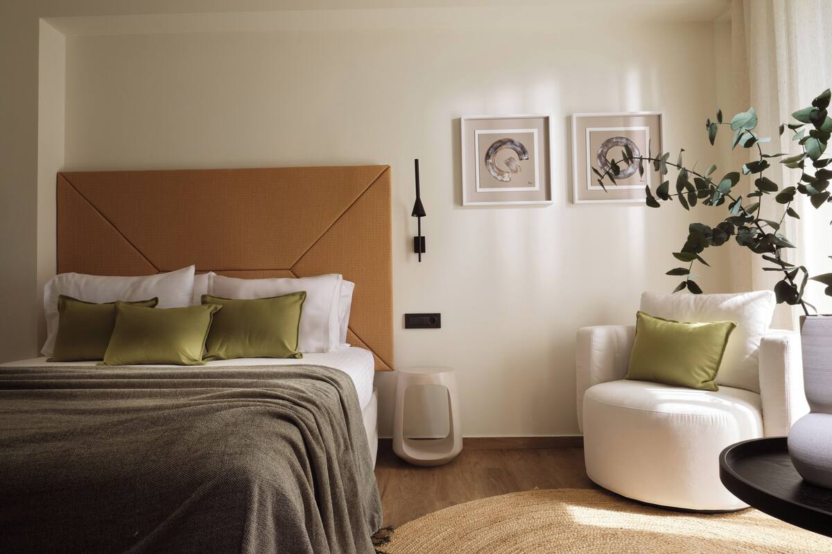 Une chambre à coucher moderne avec un grand lit, une table de chevet, une chaise et une petite table.