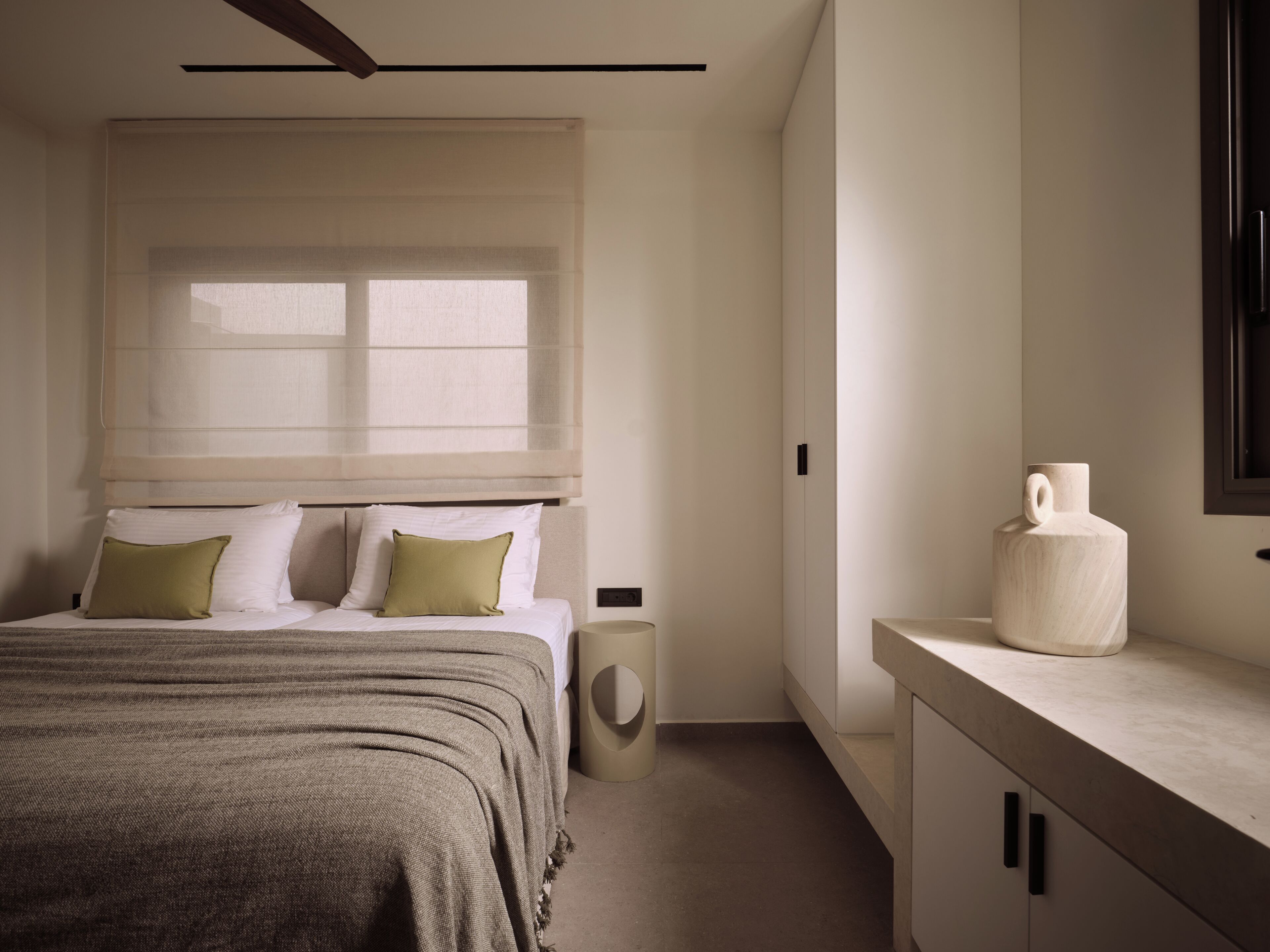A bedroom with a bed, bedside table, and a nightstand.