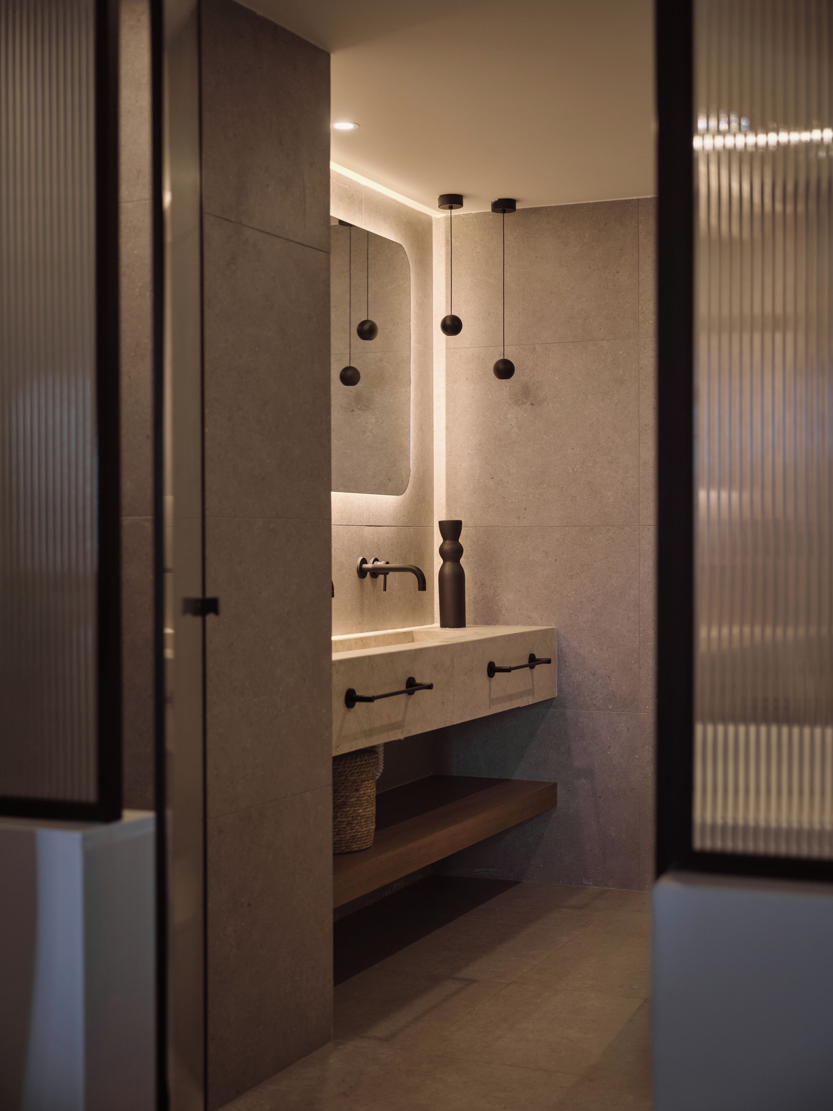 A modern bathroom with a large mirror, a sink, and a towel rack.