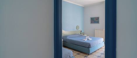 Quarto com duas camas, um radiador e um quadro pendurado na parede.